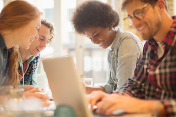 Jugendliche am Tisch sitzend, sich unterhaltend
