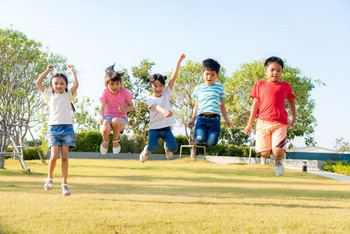 Kinder spielen im Freien und setzen gemeinsam zum Sprung an.